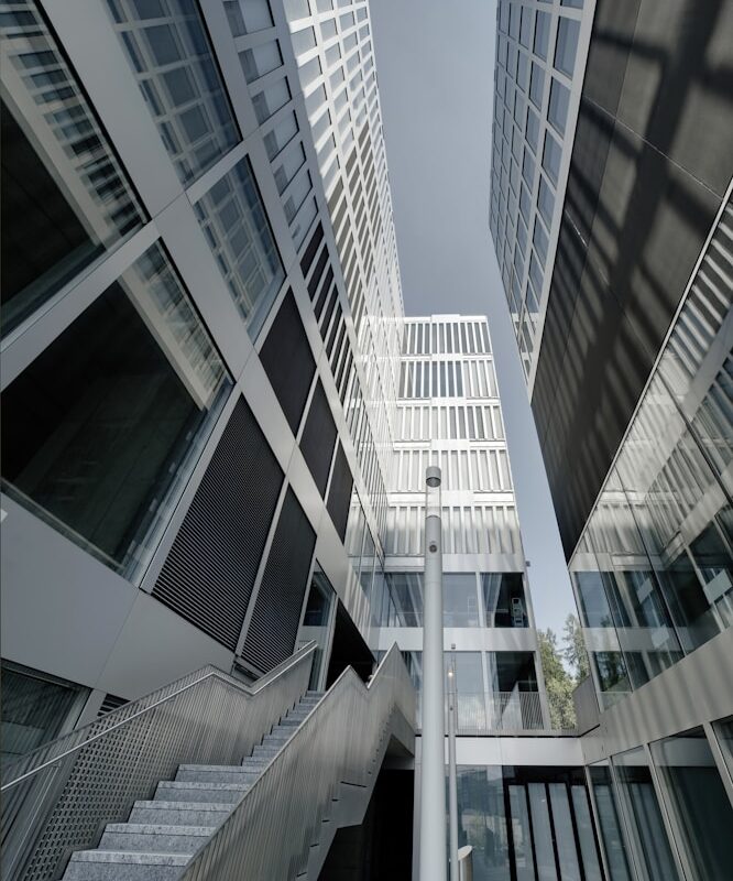 Vista dal basso tra due edifici moderni con scala e vetrate