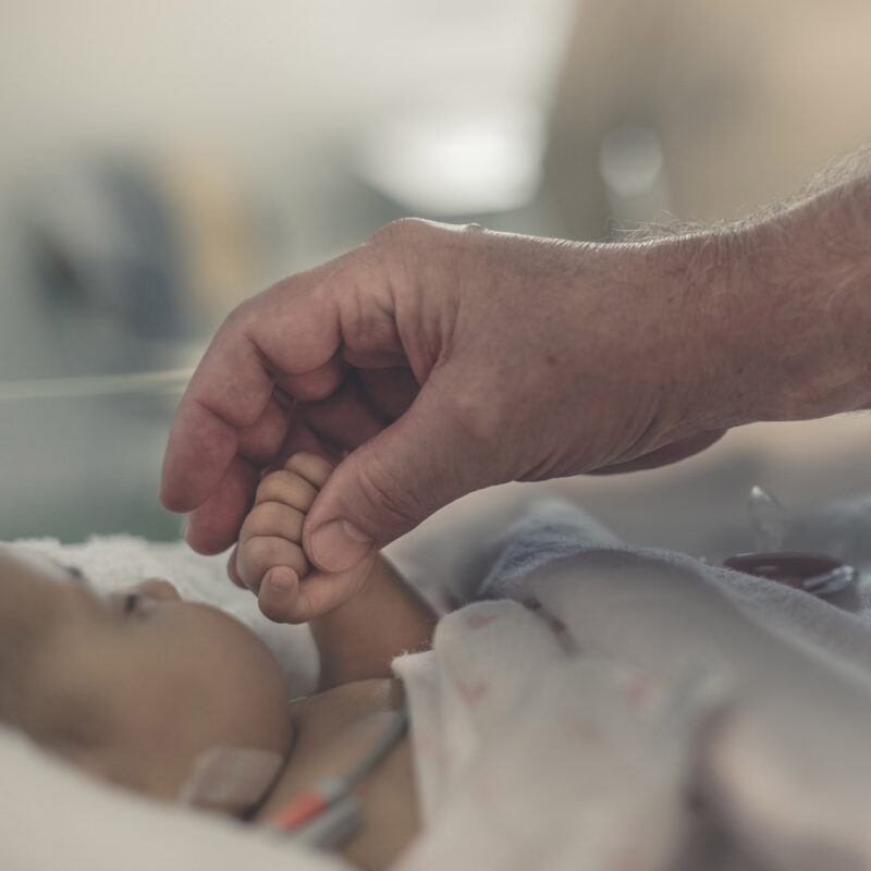 mano di medico tiene la mano di un neonato